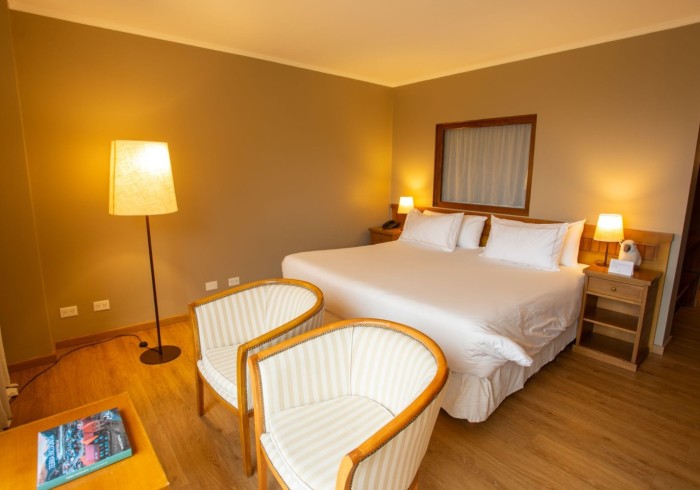Habitación Chaltén de Los Cerros del Chaltén Boutique Hotel — cama king y vistas elevadas sobre el pueblo