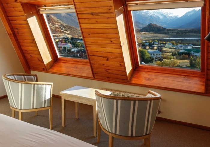 Habitación Standard de Los Cerros del Chaltén Boutique Hotel — cama doble con ventanales de piso a techo y vistas a la montaña