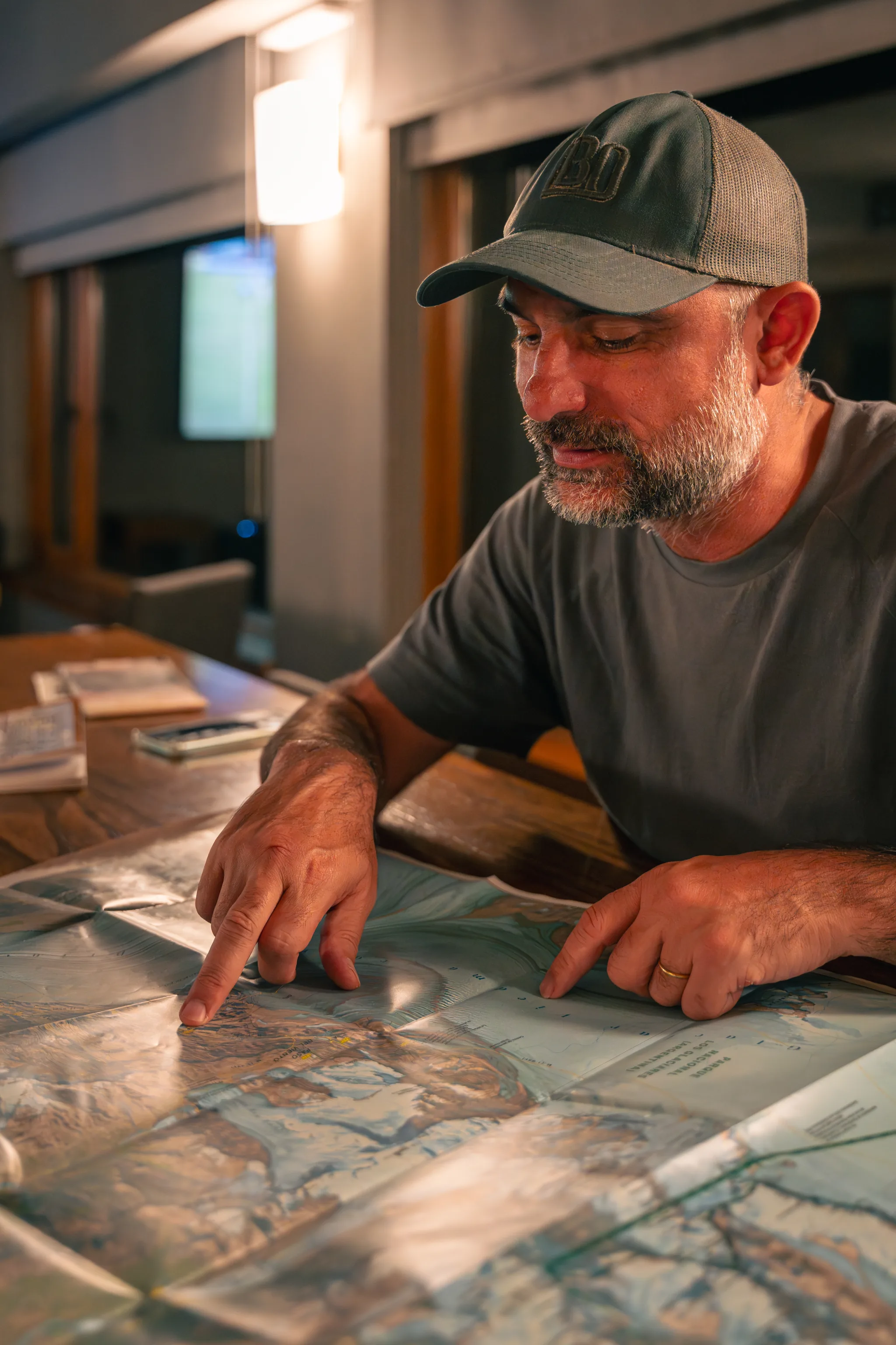 Ignacio "Nacho", anfitrión residente de Los Cerros, mostrando el mapa de senderos en el bar del hotel